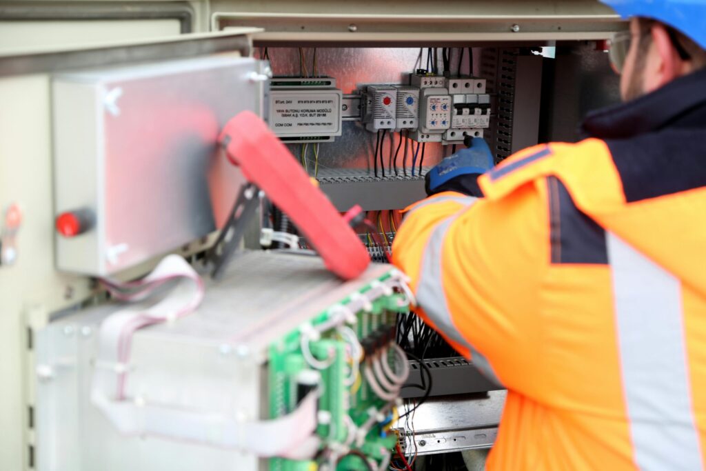 Electrician inspecting a damaged switchboard during an urgent callout.